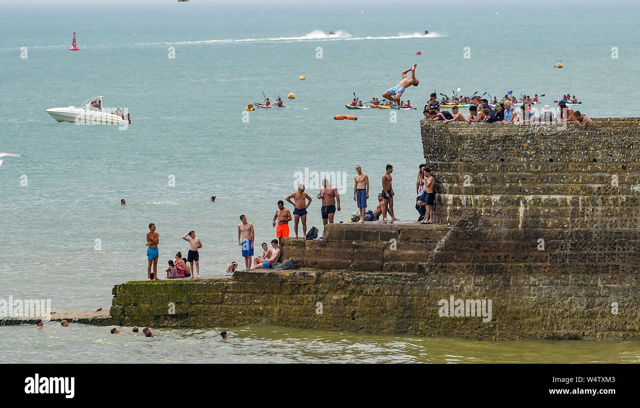 Brighton UK 25. Juli 2019 - Junge Männer tauchen Sie ein in das Meer (bekannt als grabsteineffekt) von einem groyne am Brighton Beach als Besucher einen anderen heißen, sonnigen Tag in Großbritannien genießen mit meteorologen Vorhersagen Rekordtemperaturen für Teile des Südostens. Foto: Simon Dack/Alamy leben Nachrichten Stockfoto