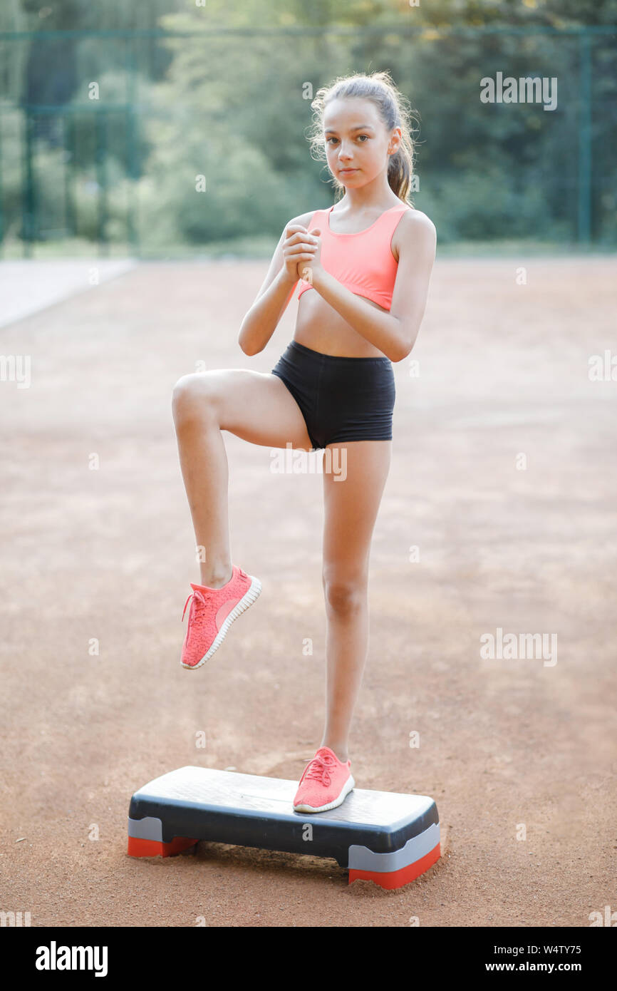 Ein nettes, hübsches junges Mädchen führt verschiedene Übungen im Freien. Lebensstil Stockfoto