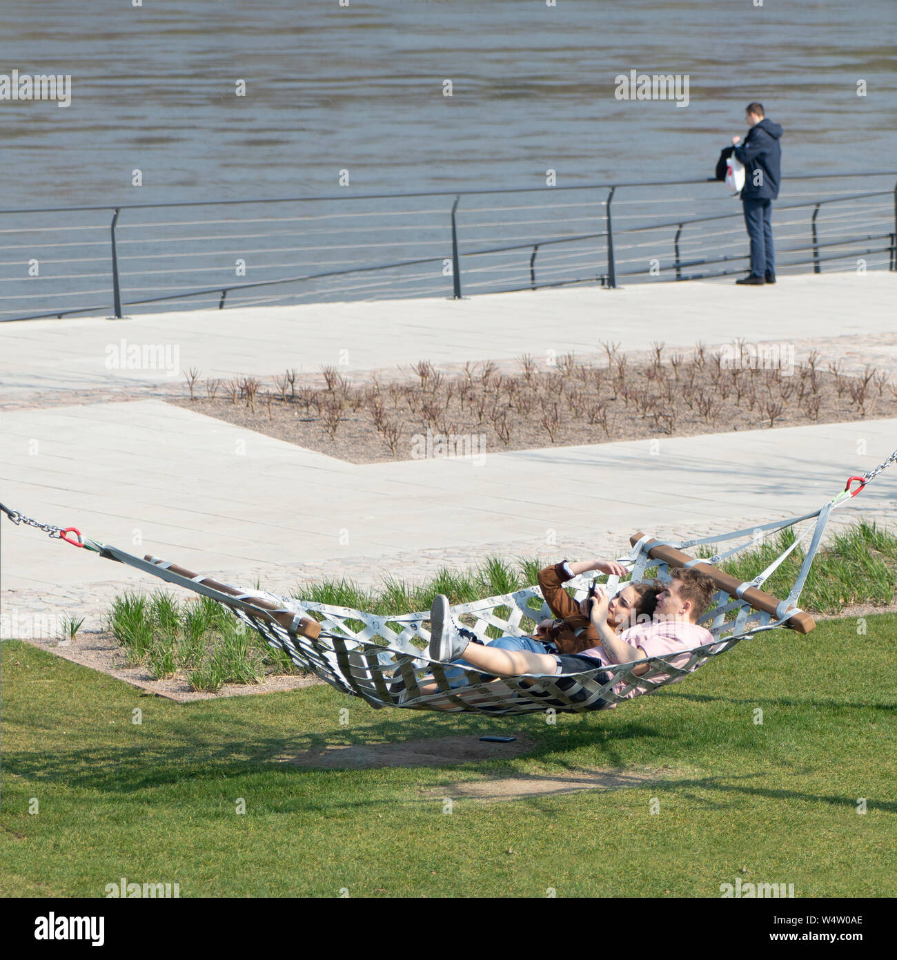 Warschau, Polen. Mai, 2019. Ein paar liegen auf einer Hängematte am Ufer der Weichsel Stockfoto