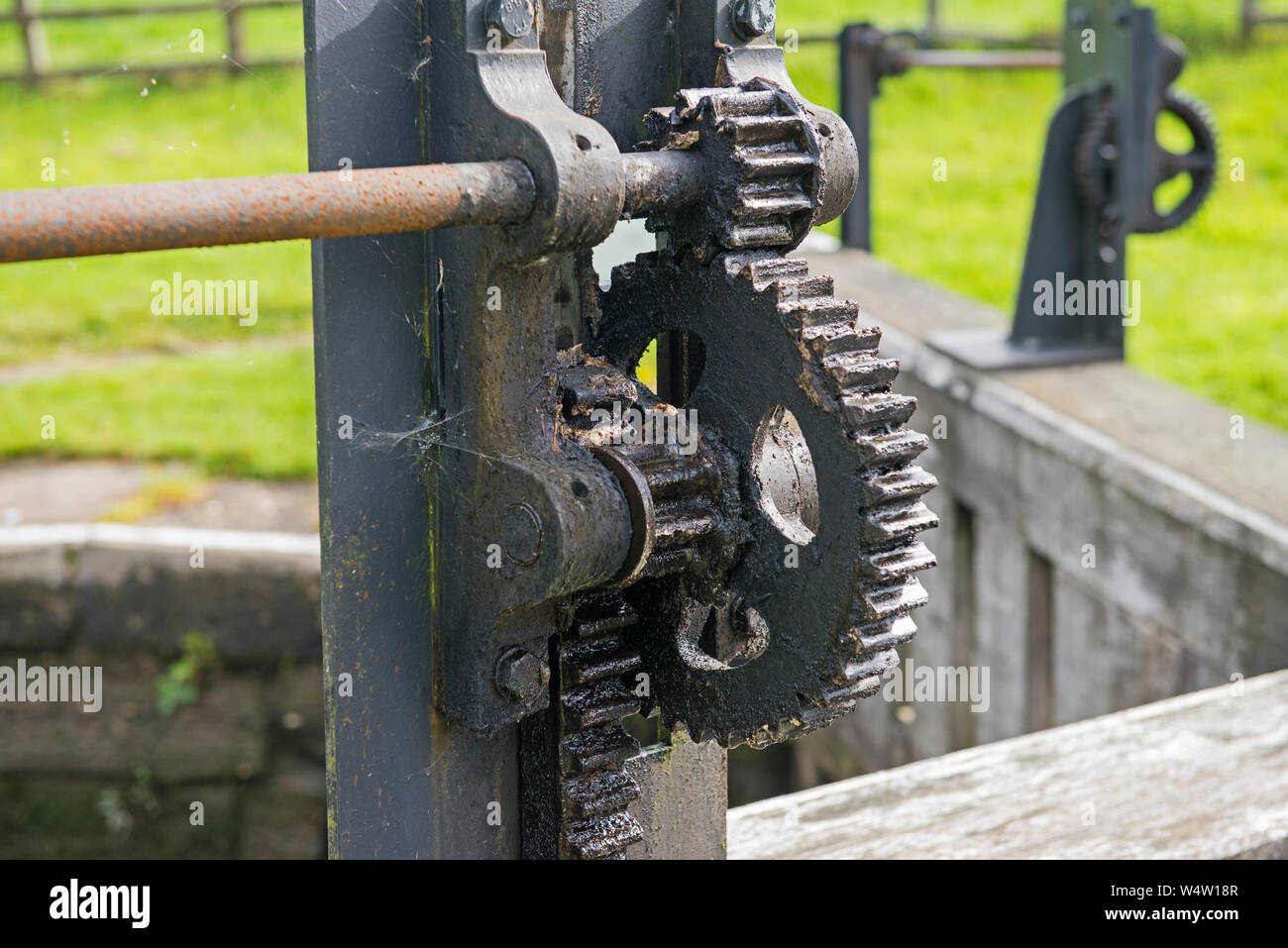 Closeup Detail des Alten gewundenen Gang Zahnrad auf der Canal Gatter verriegeln, in der ländlichen Umgebung. Stockfoto