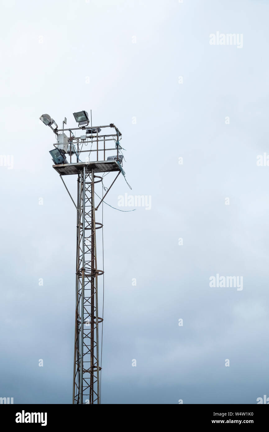 Zwei leistungsstarke Fluter auf einem Turm in einem Industriegebiet. Stockfoto