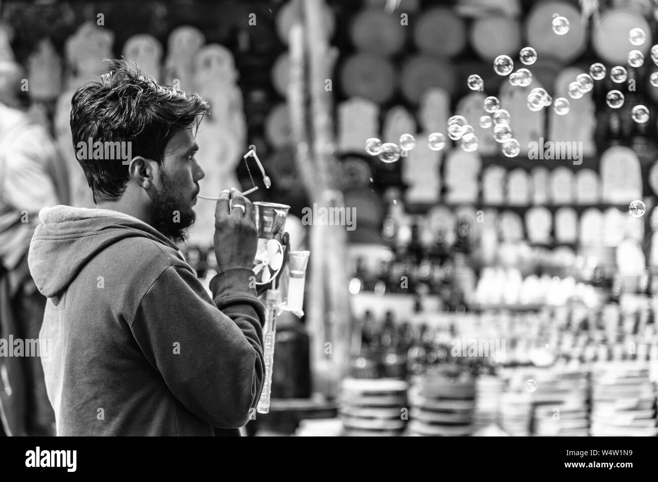 Ein nicht identifiziertes ländlichen indischen Verkäufer Blasen und Verkauf Seifenblasen mit Bubble Blower. Stockfoto