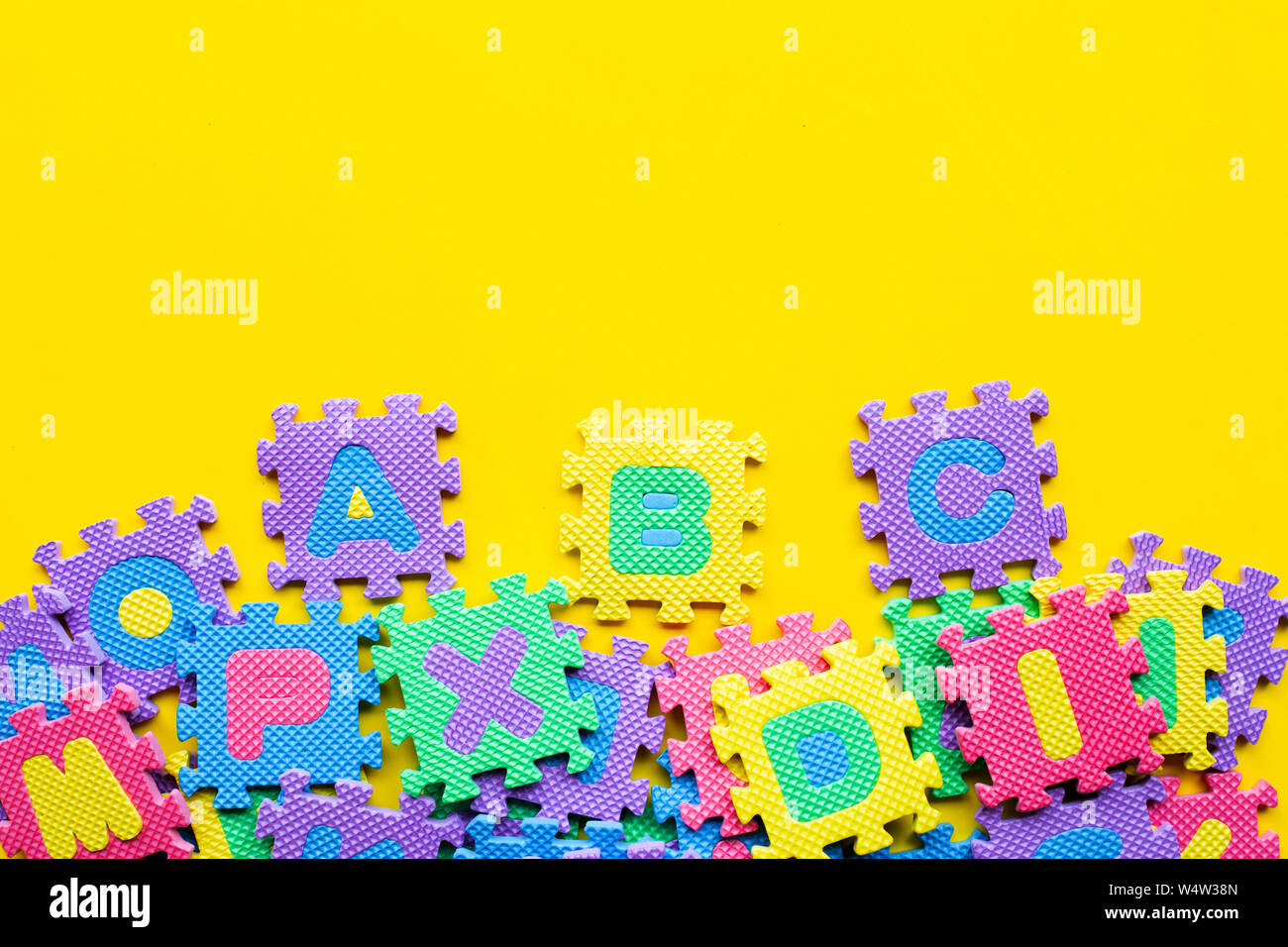 Alphabet Puzzle auf gelben Hintergrund. Ansicht von oben Stockfoto