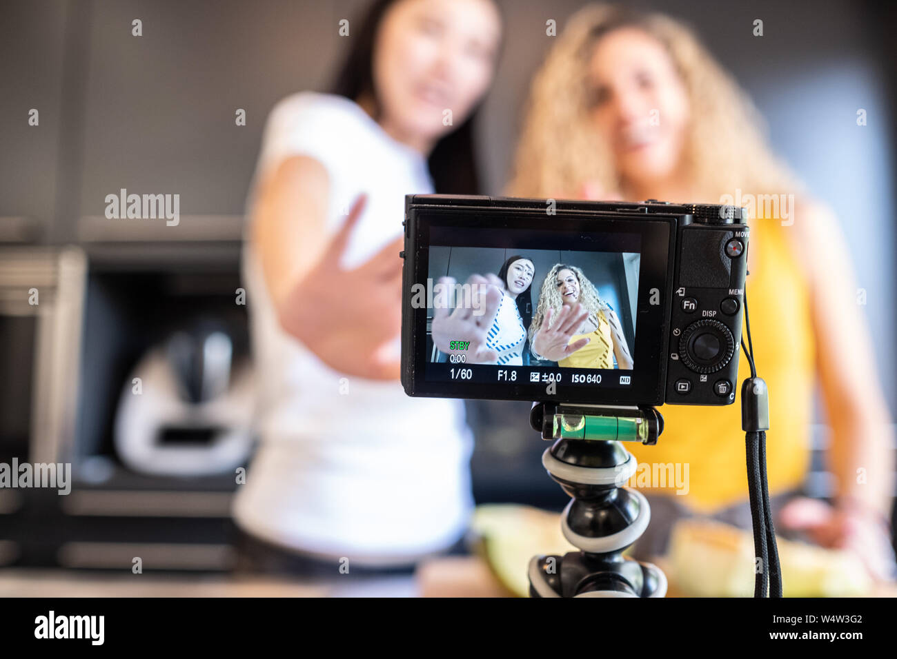 Chinesische Mädchen und weißen Mädchen schießen ein Video in der Küche für Blog Stockfoto