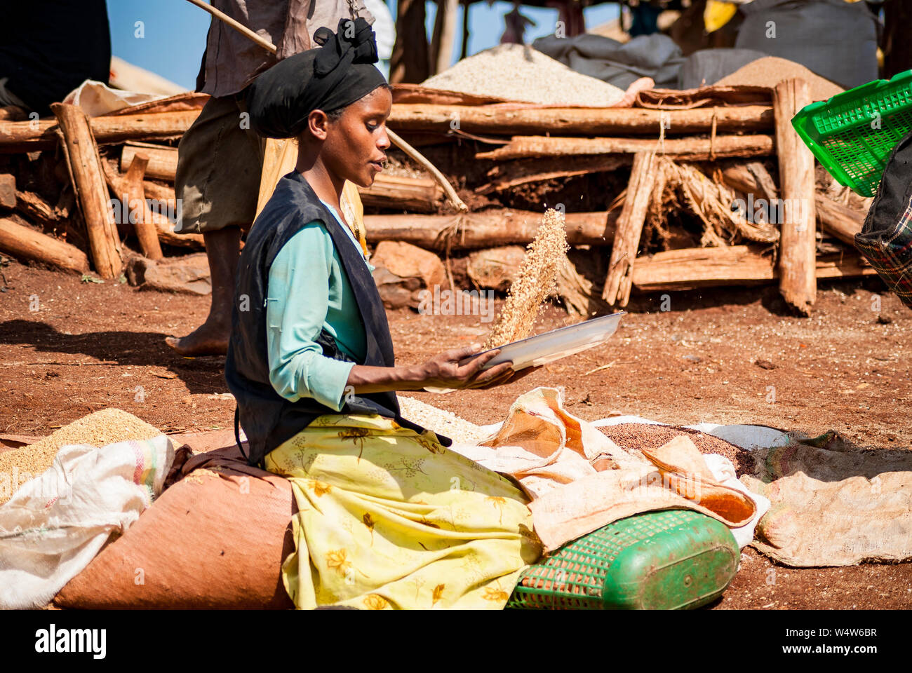 Frau sichten Korn in eine Schüssel in einem ländlichen Markt in Illubabor, Äthiopien Stockfoto