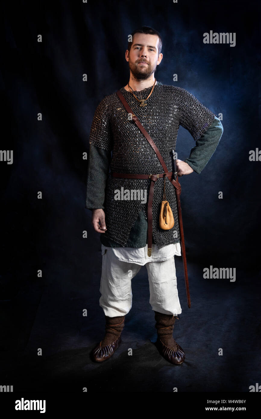 Viking warrior gekleidet in einem frühen mittelalterlichen Kostüm. Weiße junger Mann im Hemd, Chain Mail, Hosen und vintage Schuhe. Allegorie von Schutz, Sicherheit Stockfoto