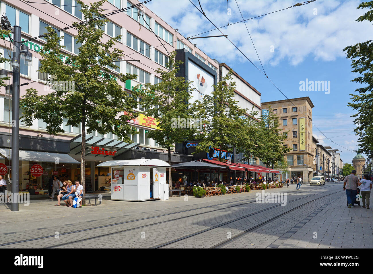 Mannheim, Deutschland - Juli 2019: Menschen zu Fuß durch die Innenstadt von Mannheim mit verschiedenen Geschäften und Cafés im Freien Stockfoto