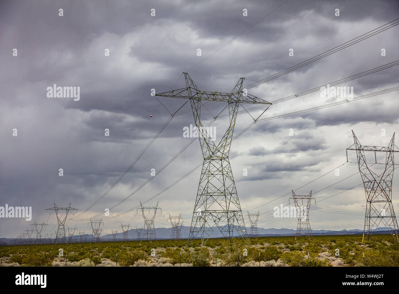 Elektrische Stromleitungen, Hochspannung, bewölkter Himmel Hintergrund, Mojave Desert, Nevada, USA Stockfoto