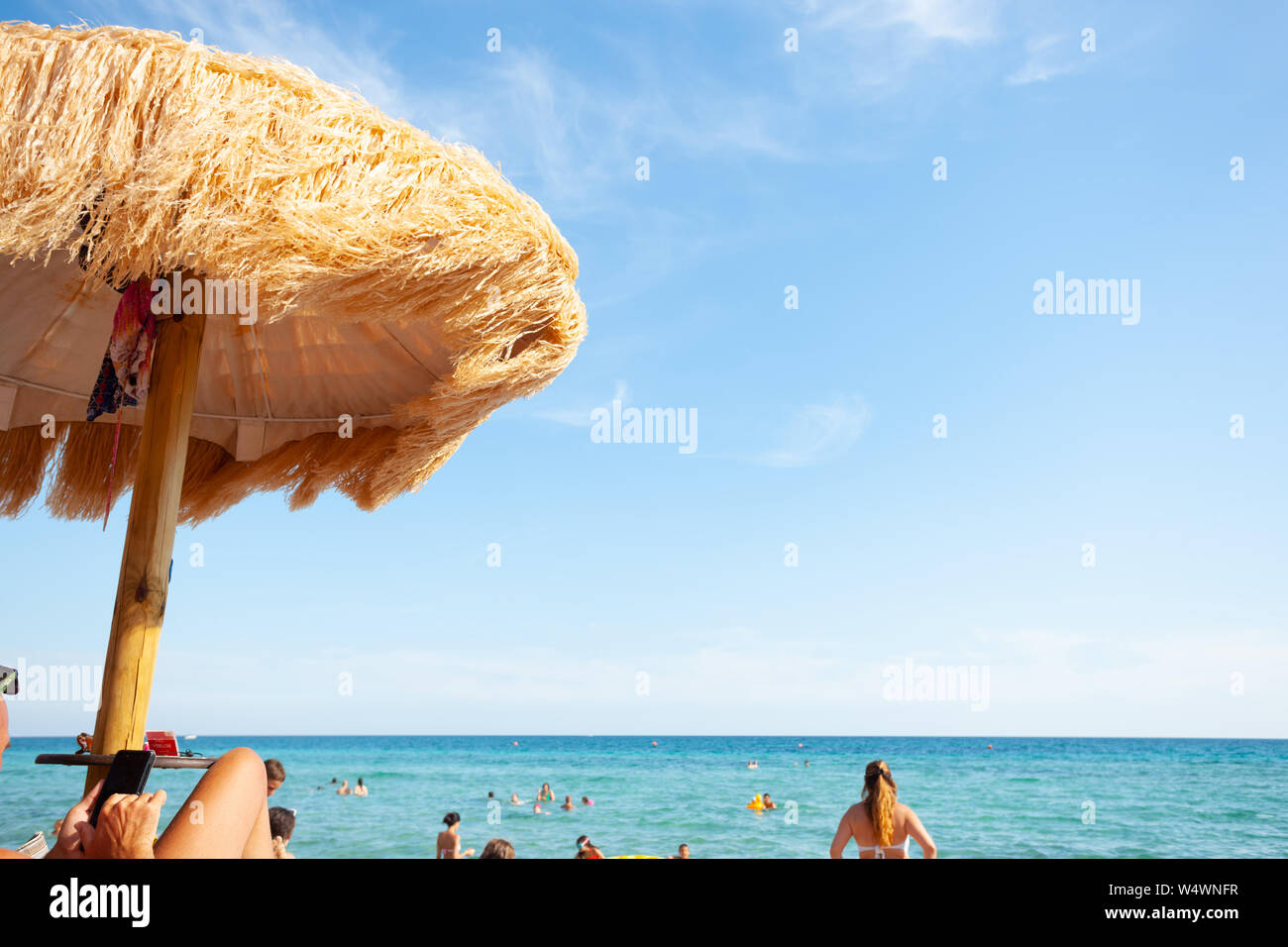 Strand schöne strohgedeckten Sonnenschirmen und leuchtend türkisfarbene Meer, tolle Erholung und Entspannung. Stockfoto