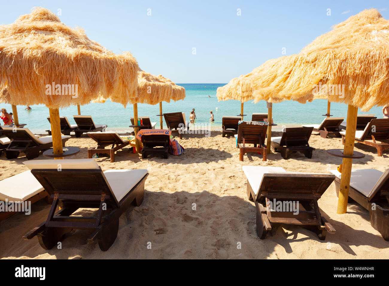 Strand schöne strohgedeckten Sonnenschirmen und leuchtend türkisfarbene Meer, tolle Erholung und Entspannung. Stockfoto