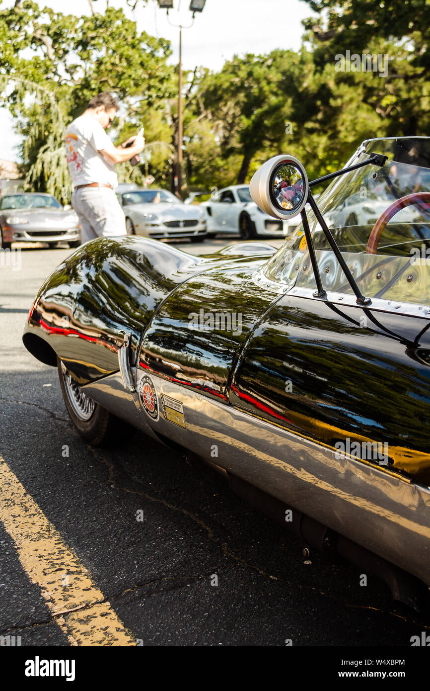 Ein Vintage Lotus Elf sitzt im Schatten an einem Pkw und Kaffee. Stockfoto