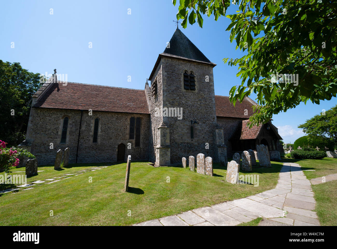 Idyllische Kirche aus dem 12. Jahrhundert und Kirchhof-Szene der St. Peter und St. Paul Kirche, West Wittering bei Chichester, West Sussex, England, Großbritannien Stockfoto