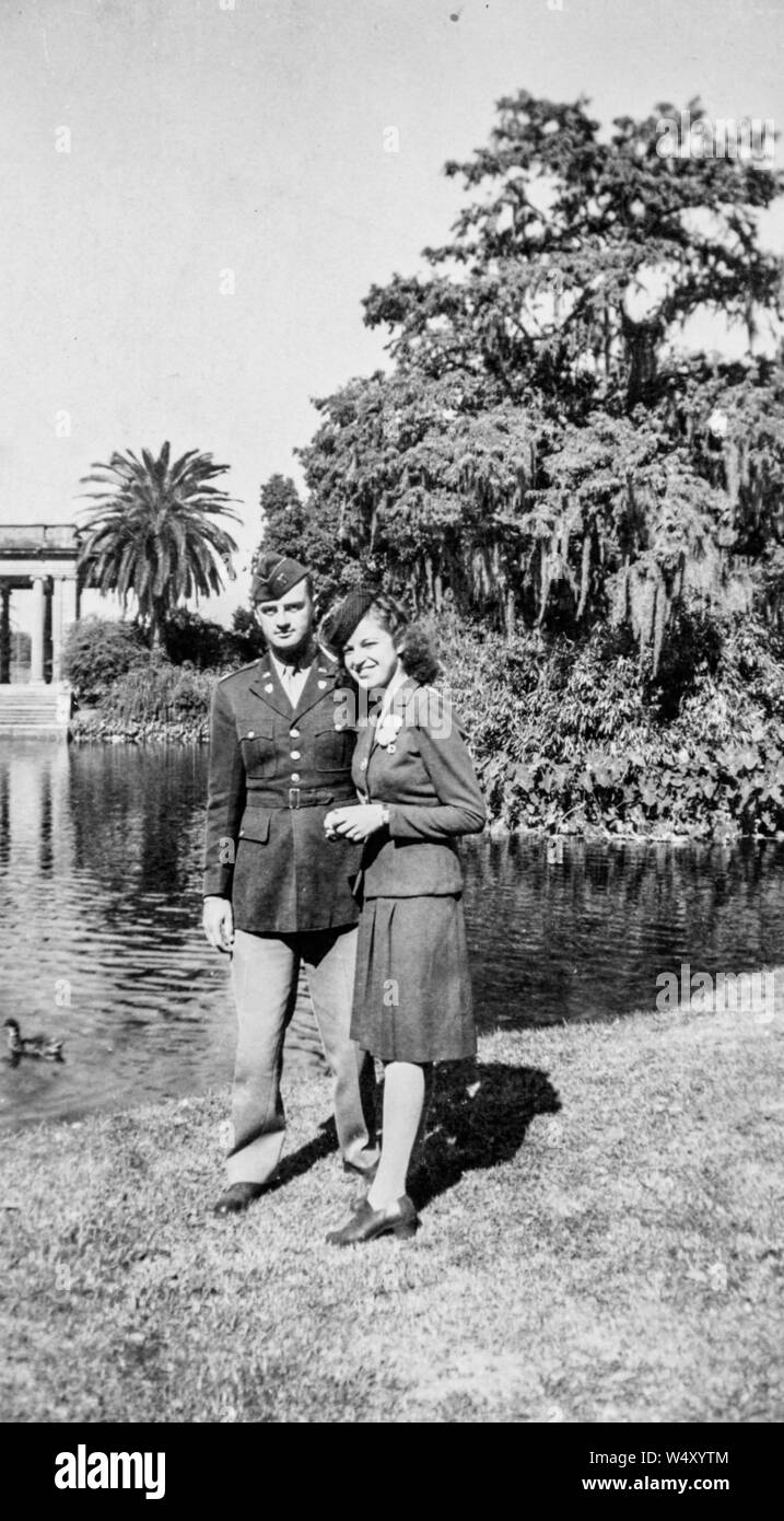 In voller Länge Porträt eines verheirateten Paares, ein Mann in Uniform und Frau in einer Bluse und Rock, stehend im Freien im Palast der Schönen Künste in San Francisco, Kalifornien, 1943. () Stockfoto