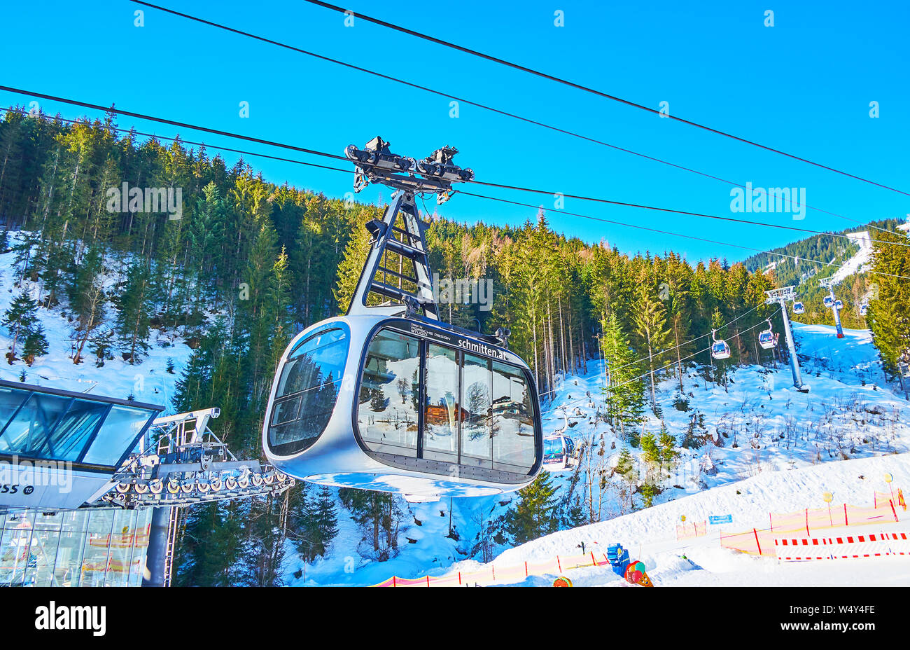 ZELL AM SEE, Österreich - 28. FEBRUAR 2019: Elegante Porsche Design Skilift kommt auf seinen unteren Station, befindet sich am Fuße des Mount Schmitten - kleinen Baue Stockfoto