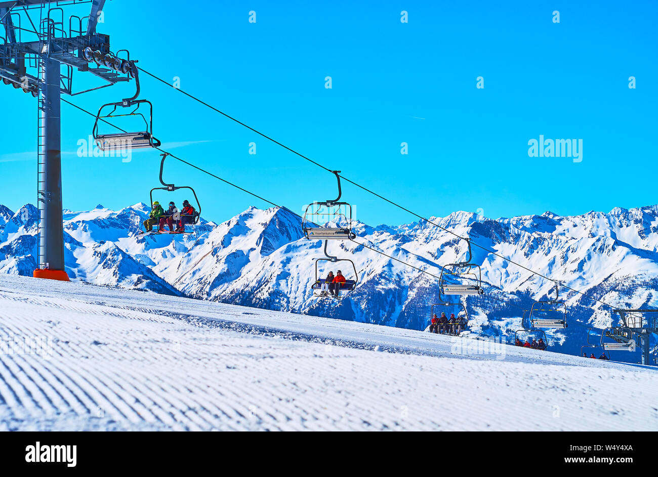 ZELL AM SEE, Österreich - 28. FEBRUAR 2019: schnell laufenden Kabinen von Kapellenbahn Sessellift auf der Oberseite von Snowbound Schmittenhohe Berg, bedeckt mit nume Stockfoto