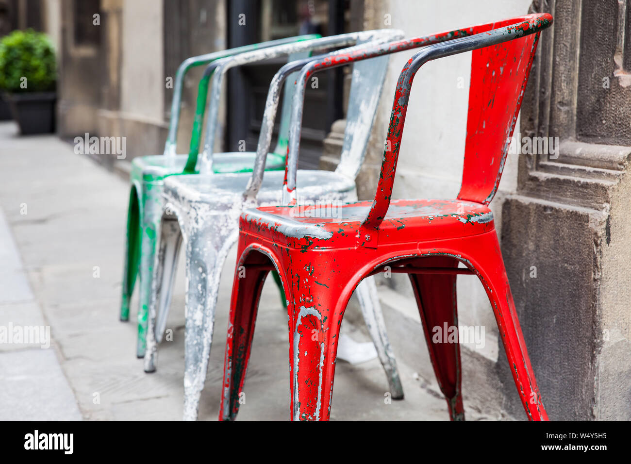 Drei Leere klapprigen bunte Stühle an die historischen Straßen von Florenz Stockfoto