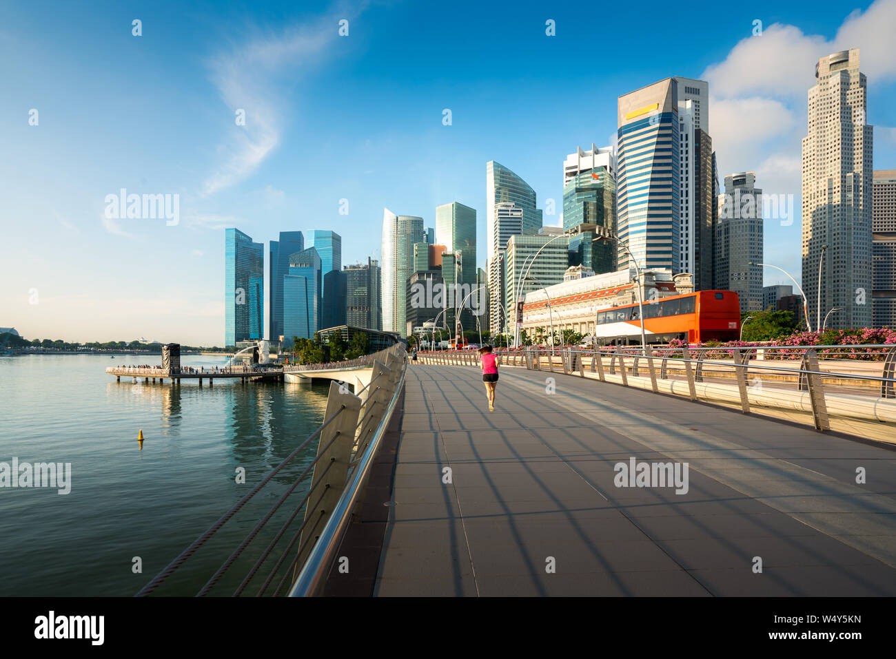 Fußgänger entlang der Brücke in der Nähe der Marina Bay in Singapur mit Singapore Hochhaus im Hintergrund Stockfoto