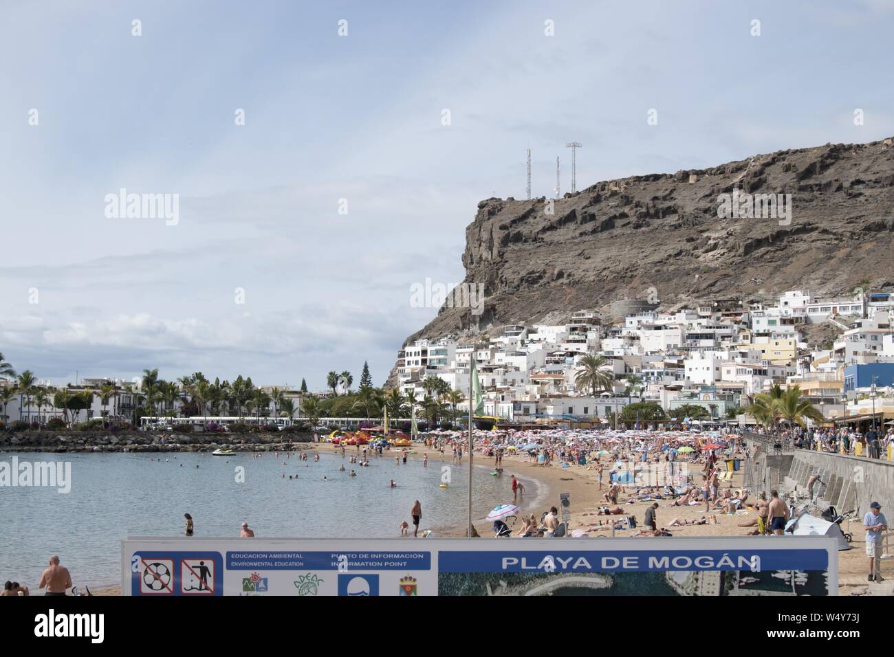 Masse der Touristen am Strand von Puerto de Mogan, einem Fischerdorf an der Südwestküste der Insel Gran Canaria, Kanarische Inseln, Spanien, 15. November 2017. () Stockfoto