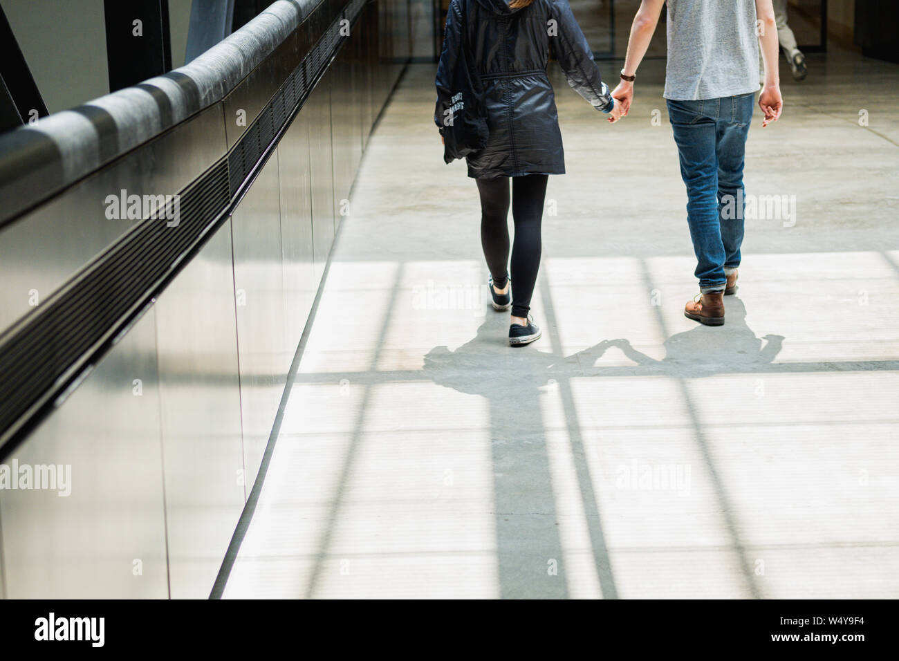 Ein paar Hände halten Kreuzung Gehweg bei Tageslicht - Tate Modern - London - Juli 2019 Stockfoto