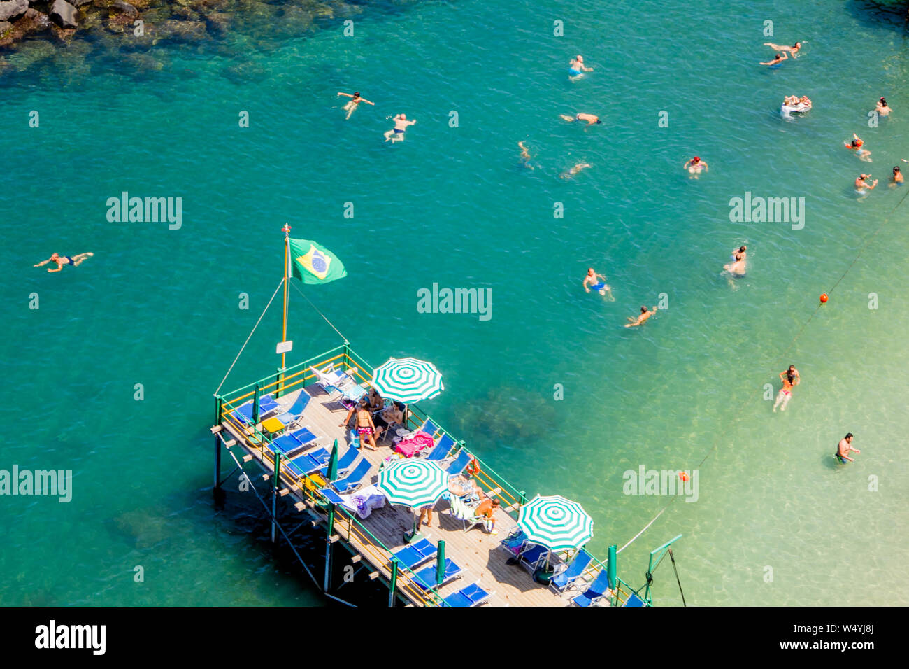 Sorrento, Italien - 14 Juli 2012: Menschen am Strand in Sorrent an einem heißen Sommertag mit Ruhe und erfrischende, blaue und grüne Wasser Stockfoto