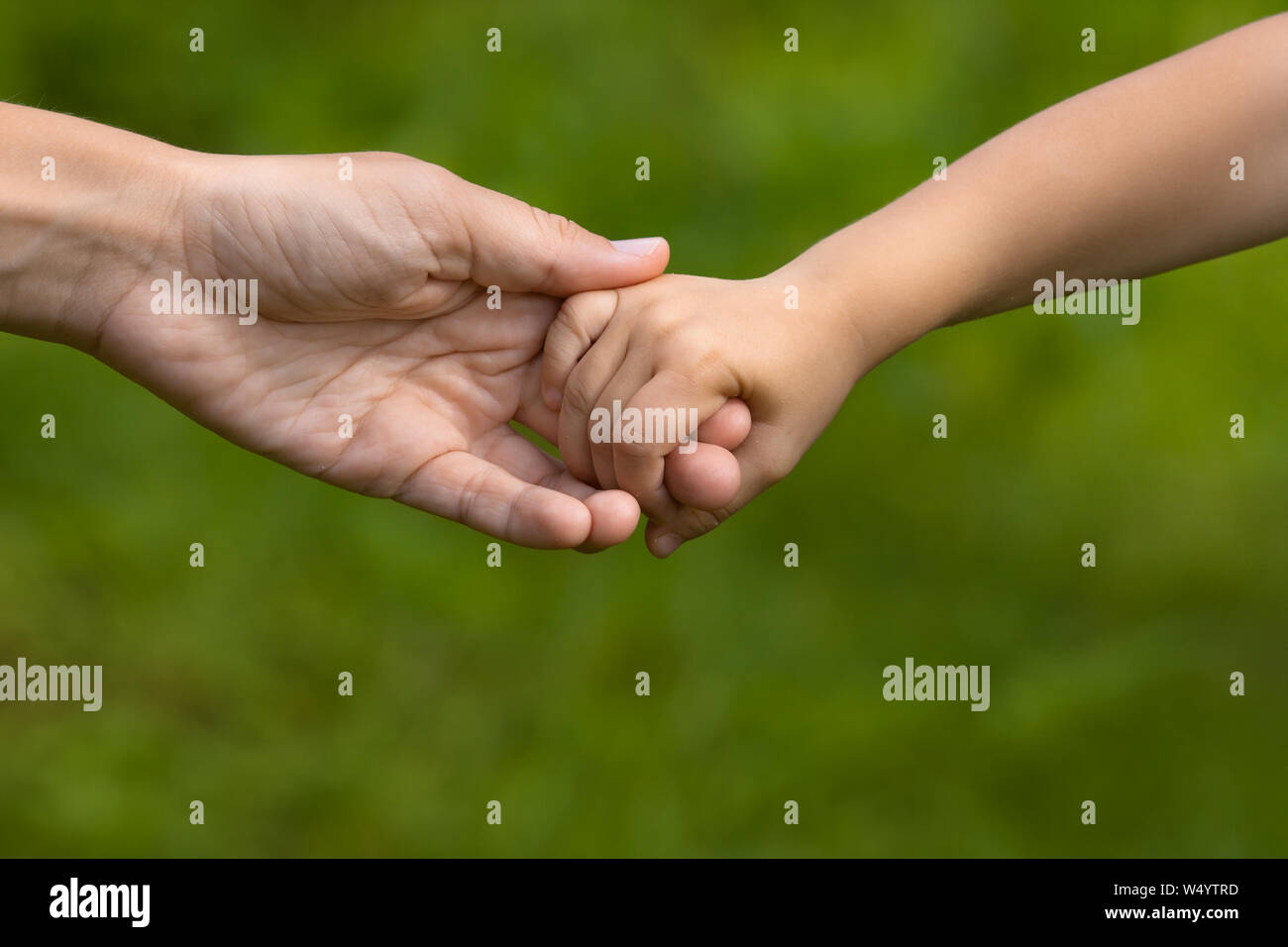 Mutter mit einer Hand Ihrer Tochter auf unscharfen Hintergrund, Nahaufnahme Stockfoto