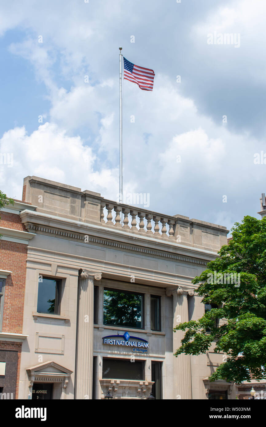 "Holland, Michigan/USA - 17.07.2019: First National Bank von Michigan ein Jahrgang alte Gebäude der mit USA-Flagge an einem sonnigen Tag." Stockfoto