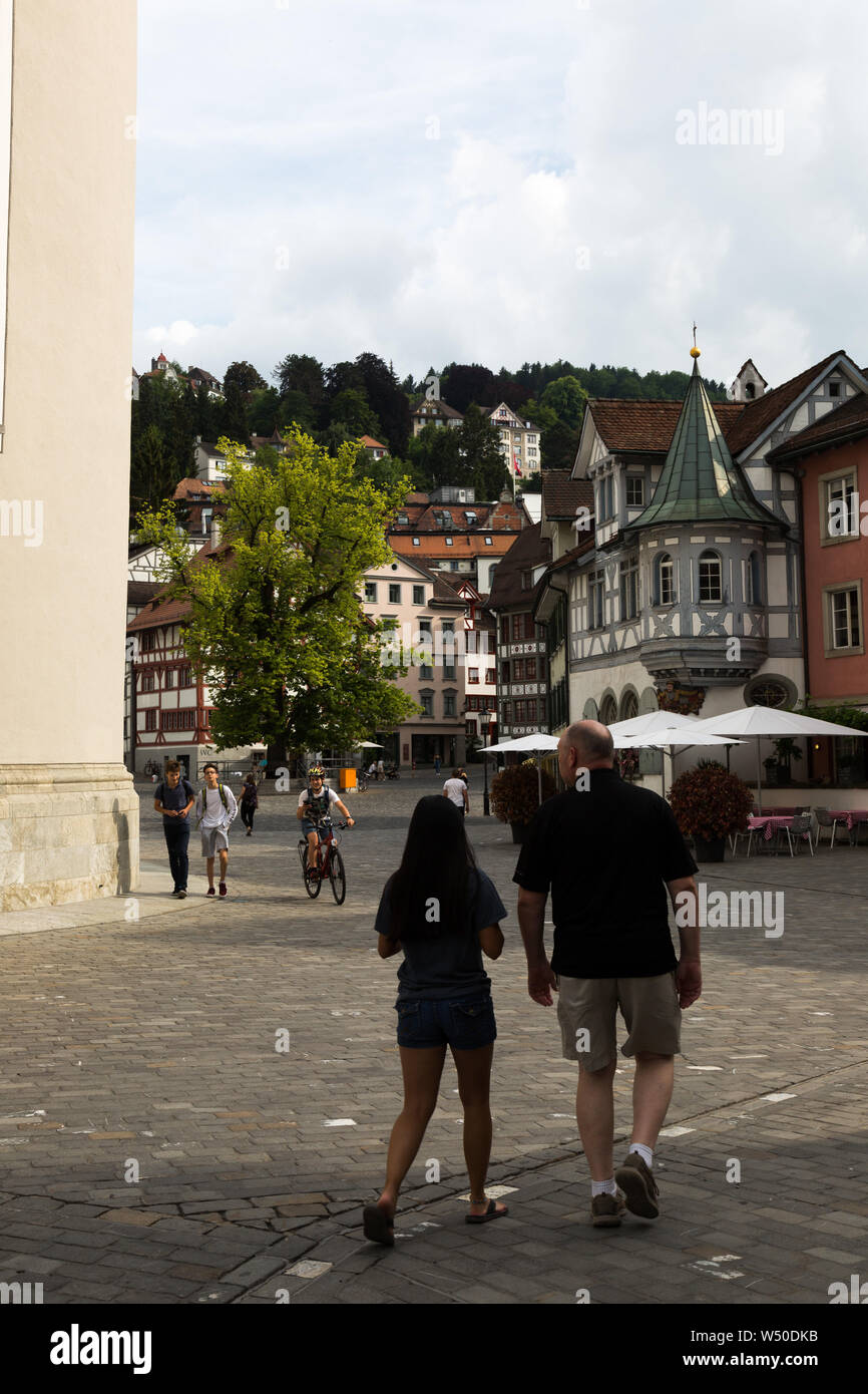 Fußgänger erkunden den Gallusplatz an einem schönen Schweizer Tag in St. Gallen, Schweiz. Stockfoto