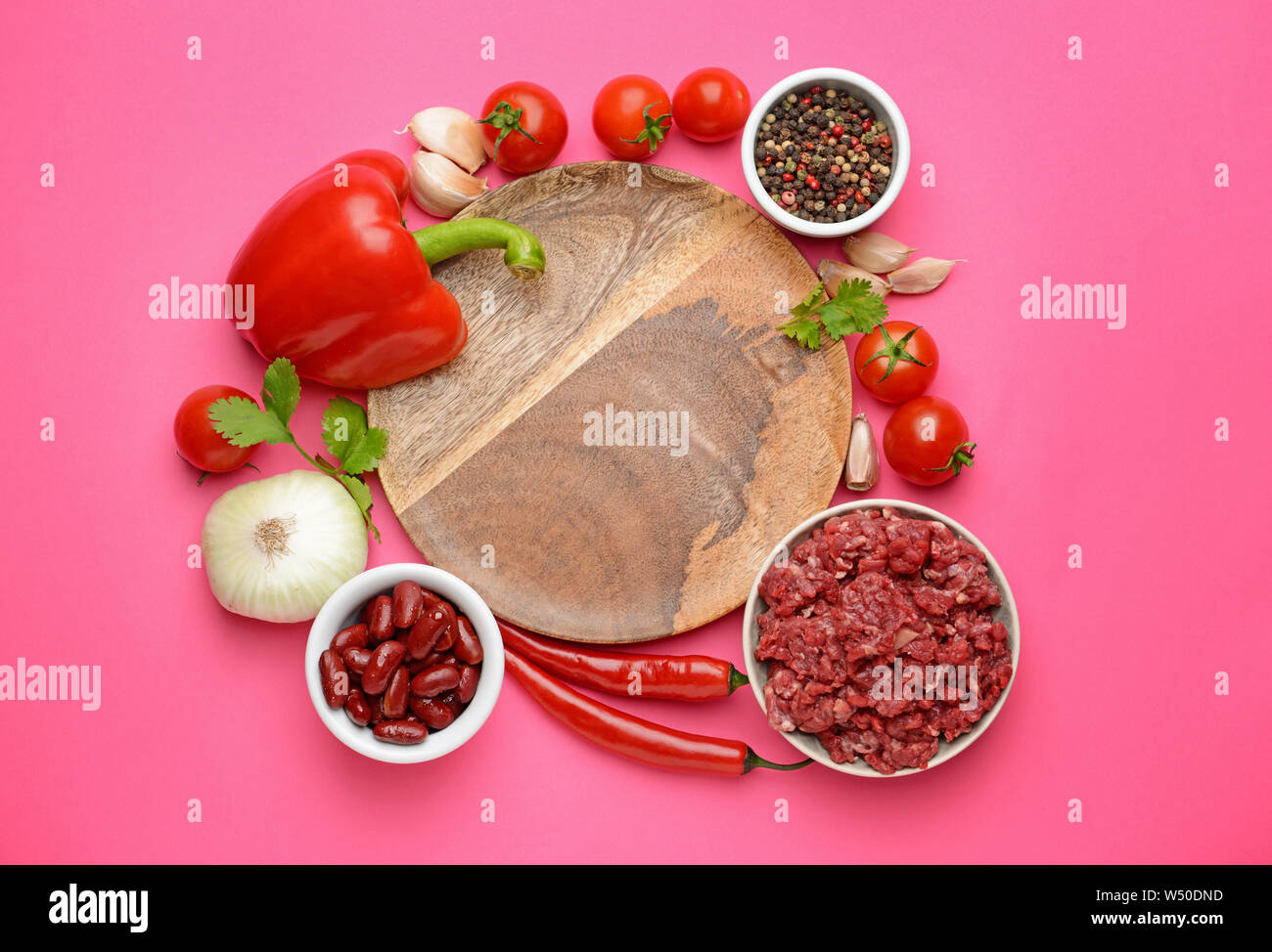 Zutaten für Chili con carne mit Platte auf farbigen Hintergrund Stockfoto
