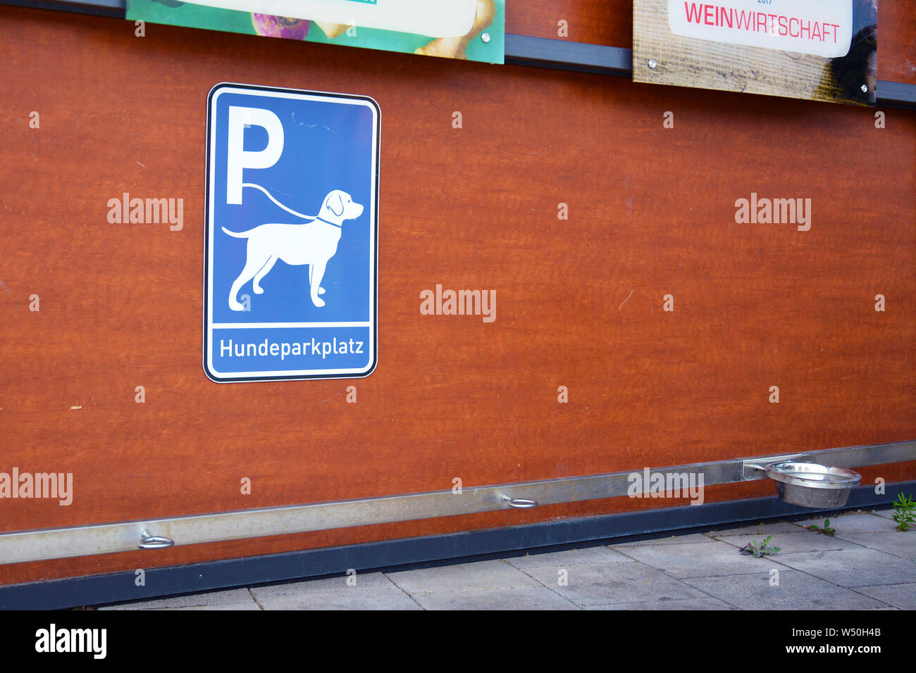 'Dog Parkplatz Station' für Hunde warten auf Besitzer außerhalb der Läden mit blauen Schild mit Hund an der Leine, Haken zum Befestigen von Leine und bewässerungskugeln Stockfoto