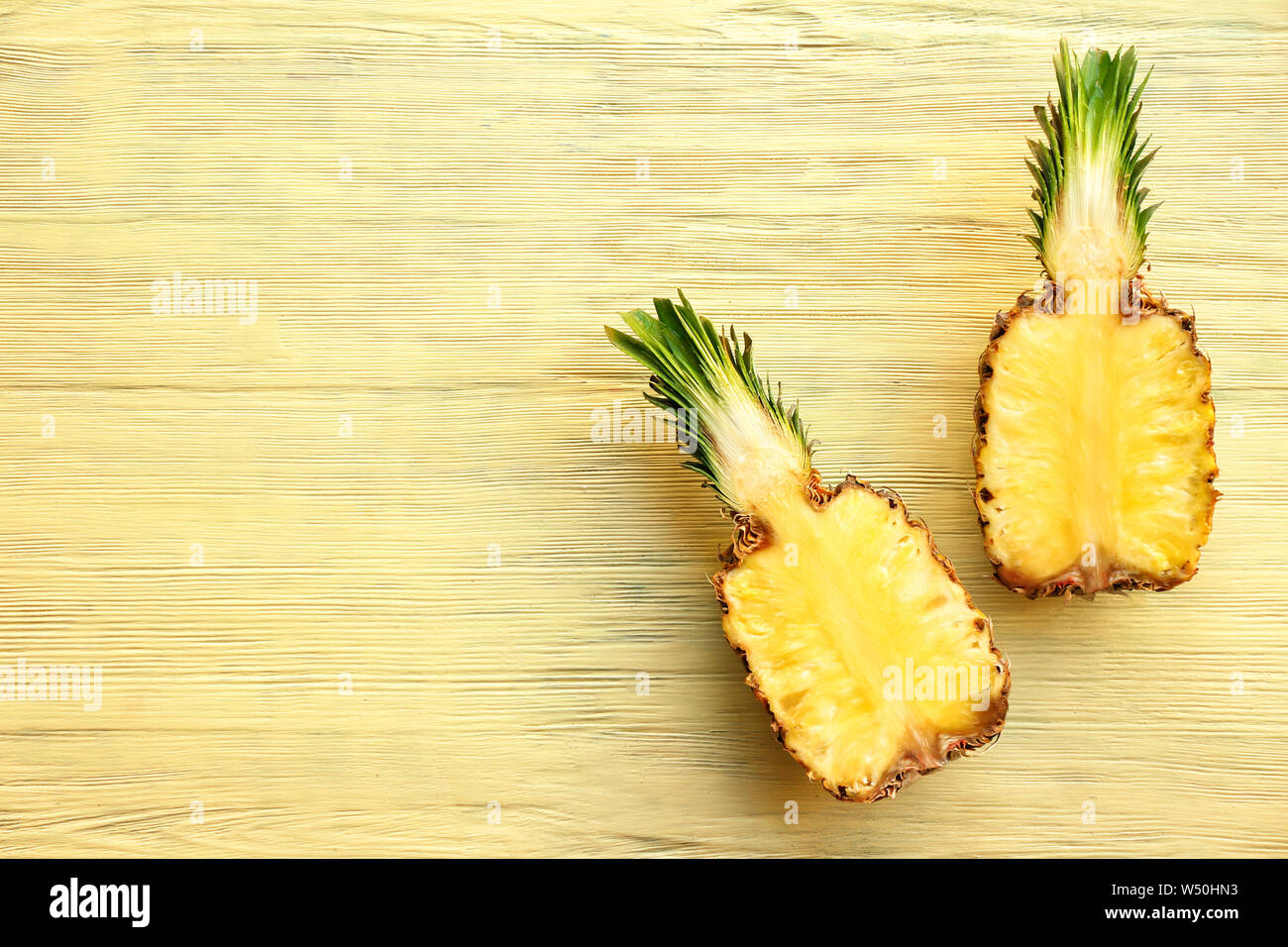 Hälften der süßen Ananas auf Holz- Hintergrund Stockfoto