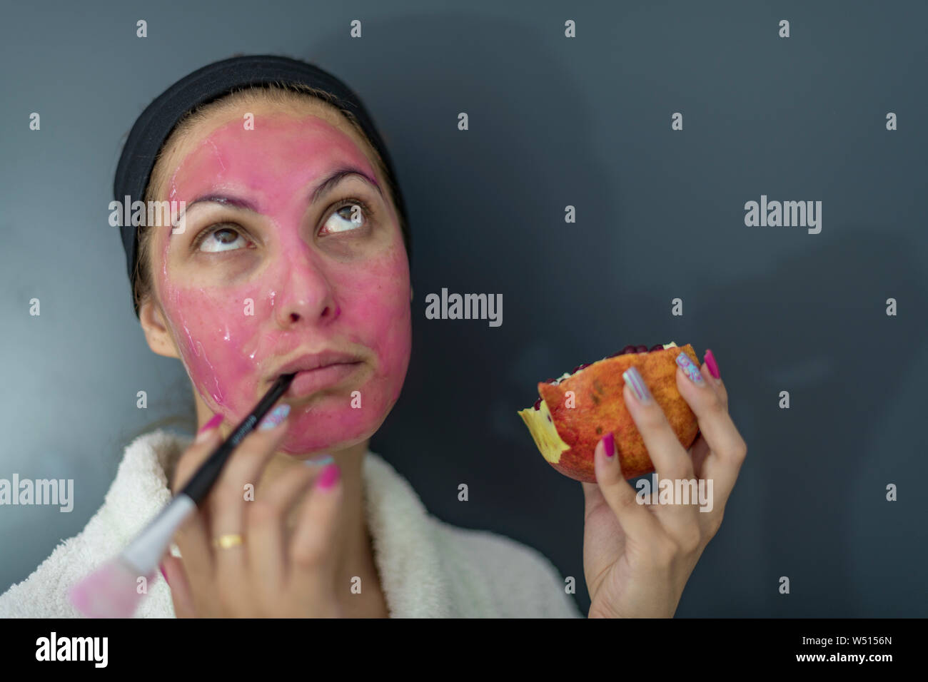 Nachdenklich Dame mit einem Granatapfel Maske im Gesicht - Organische Schönheit Kosmetik - Close-up Stockfoto