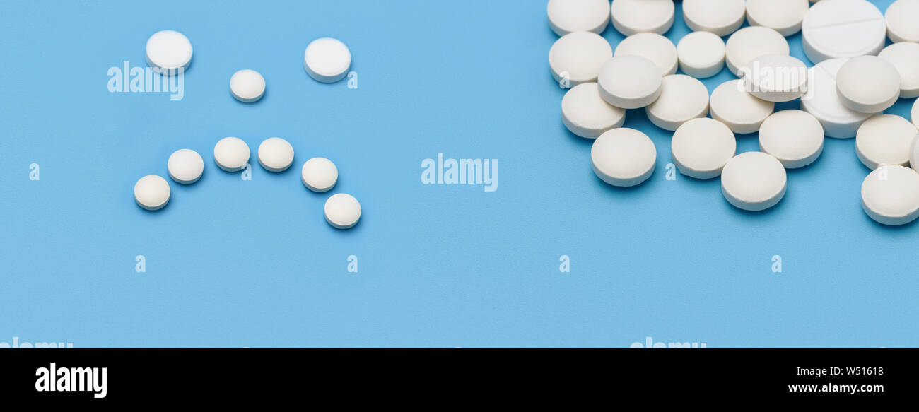 Banner. Auf der rechten Seite eine Menge runde weiße Tabletten auf einem blauen Hintergrund, auf der linken Seite der Tabletten mit traurigen Gefühlen gefüttert Stockfoto