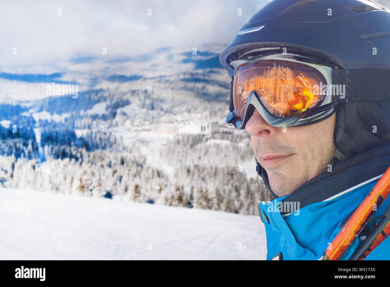 Porträt der Skifahrer, der Mann in der blauen Ski Jacke, Helm und Brille gegen Schnee Wald Panorama mit Kopie Raum Stockfoto