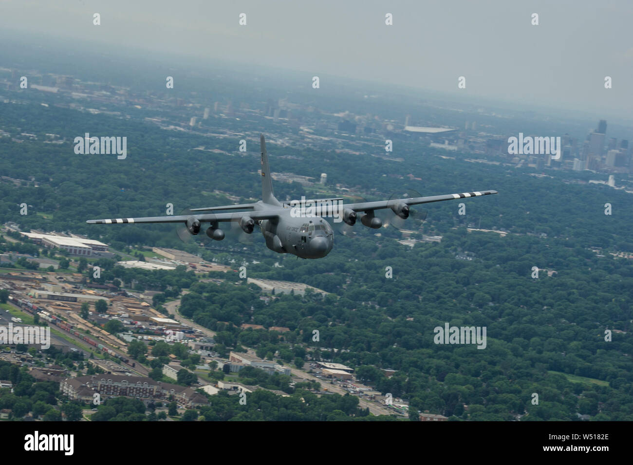 Ein US Air Force C-130H Hercules Flugzeuge aus der 96th Airlift Squadron, Minneapolis-St. Paul Luft finden Station, Minn., fliegen über Minnesota, 16. Juli 2019. Flugzeuge Anzahl 23284 wurde mit DEM ZWEITEN WELTKRIEG invasion Streifen zu Ehren der 75. Jahrestag des D-Day gemalt. Ursprünglich als 96 Truppentransporter Geschwader, das 96 Th aktiviert, fallengelassen Fallschirmjäger der Luftlandedivision in der Normandie während des D-Day Invasion und flog zahlreiche Missionen in den Verstärkungen holen und Material erforderlich während des Krieges. (U.S. Air Force Foto von Tech. Sgt. Bernstein E.N. Kurka) Stockfoto