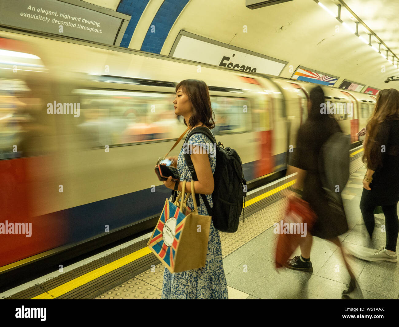 Dame, die an einem U-Bahnhof in London auf den Zug wartet Stockfoto