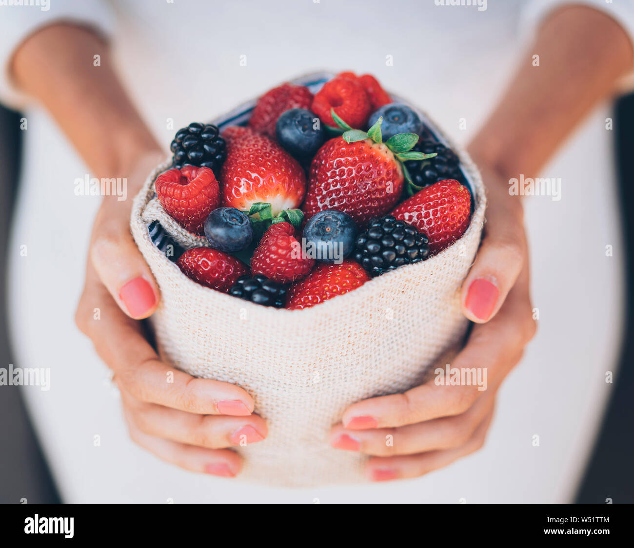 Süße Beeren mix in die Hände eines Mädchens Stockfoto