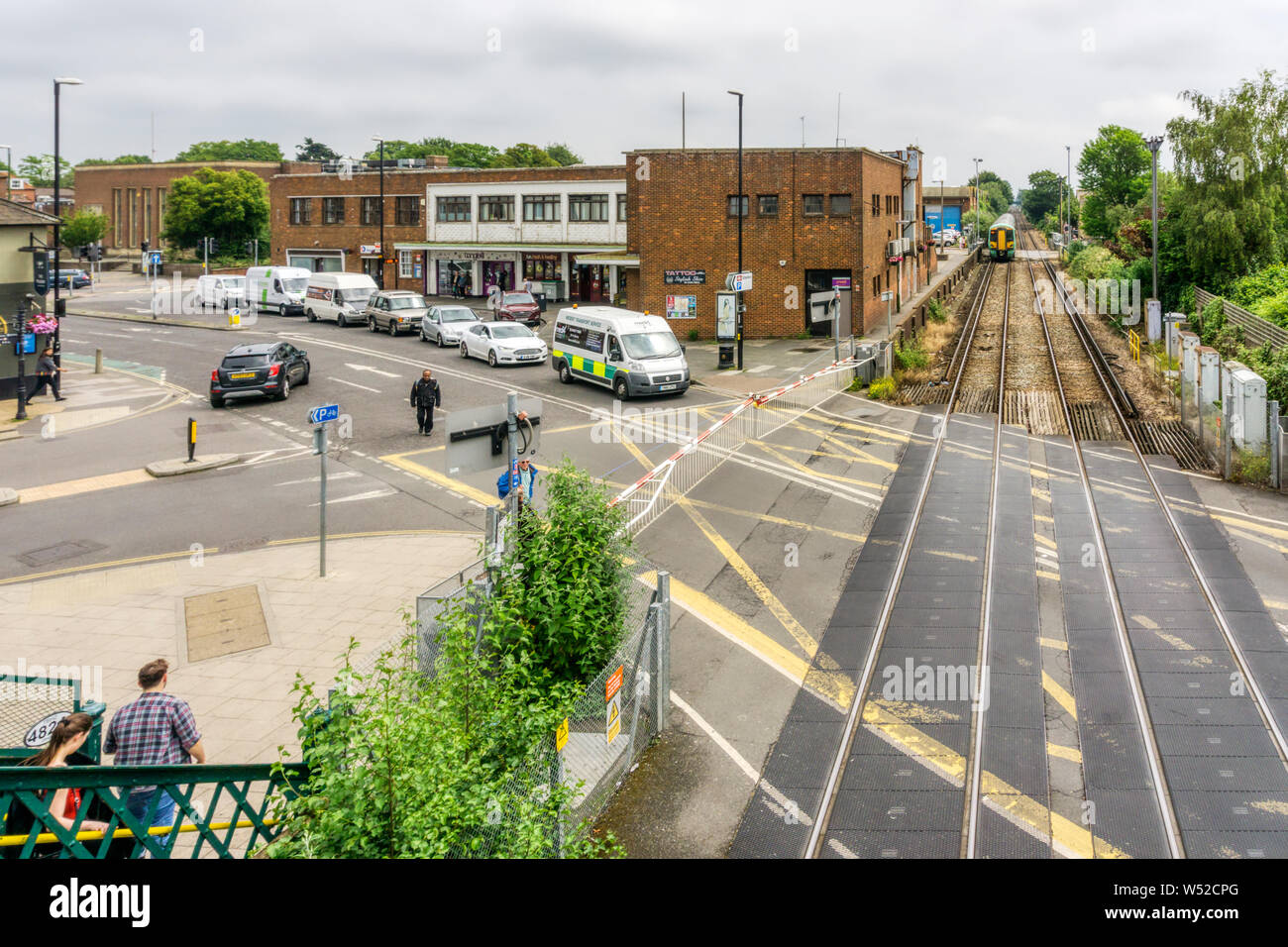 Geschlossen Bahnübergang mit automatischen Schranken vor dem Bahnhof von Chichester, West Sussex. Stockfoto