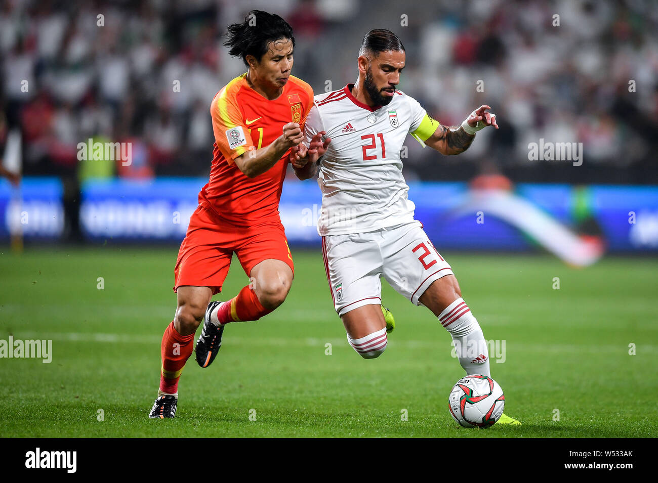 Hao Junmin von China, Links, Herausforderungen Ashkan Dejagah des Iran in Ihrem Viertelfinale bei der Asienmeisterschaft 2019 in Abu Dhabi, Vereinigte Arabische Emir Stockfoto