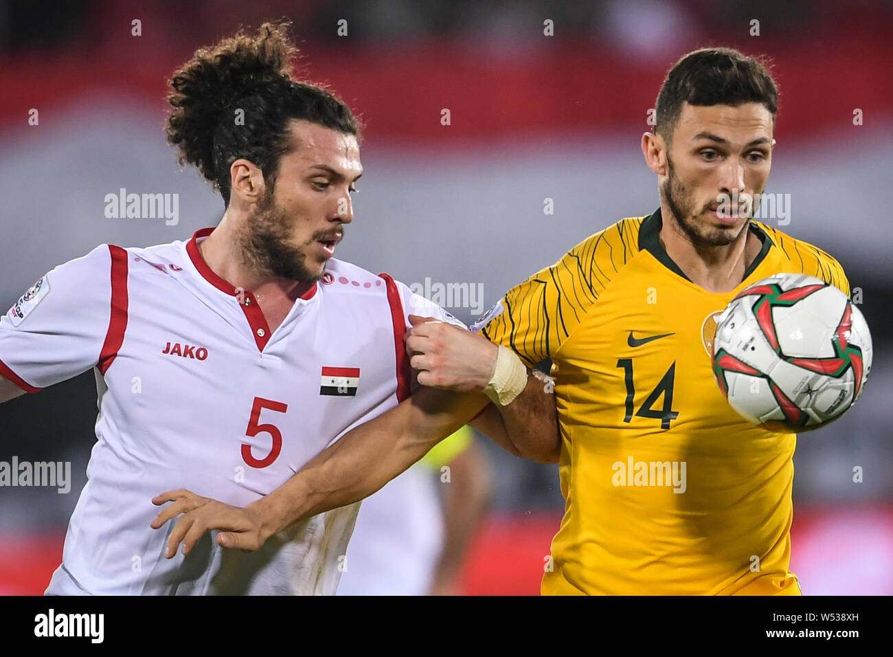 Apostolos Giannou von Australien, rechts, Herausforderungen Omar Midani von Syrien in der AFC Asian Cup Gruppe B Spiel in Al Ain, Vereinigte Arabische Emirate, 15 März Stockfoto