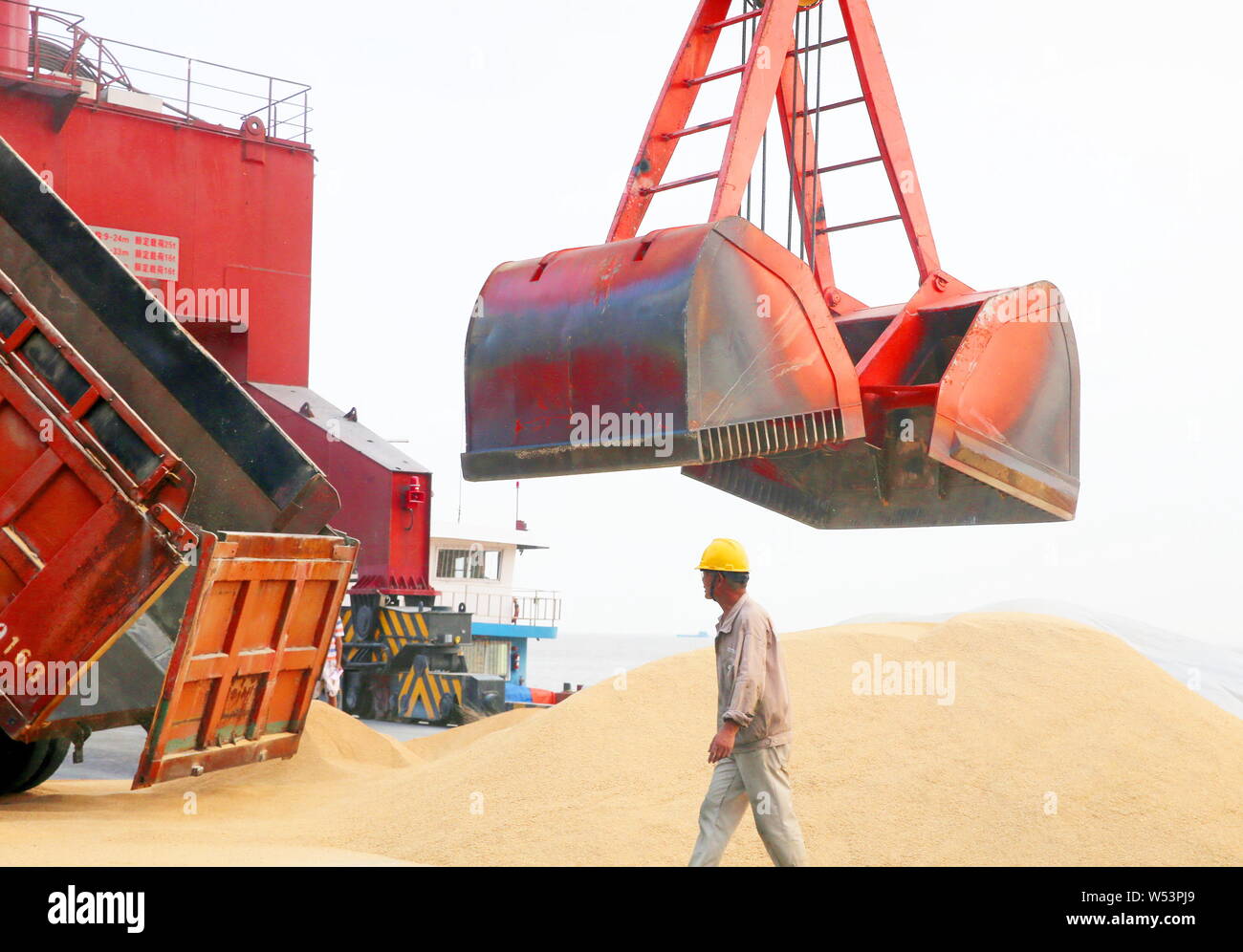 ------ Kran Fahrzeug Lasten eingeführten Sojabohnen auf eine Ladung Boot im Hafen von Nantong in Nantong City, East China Jiangsu Provinz, am 6. August 2018. Stockfoto