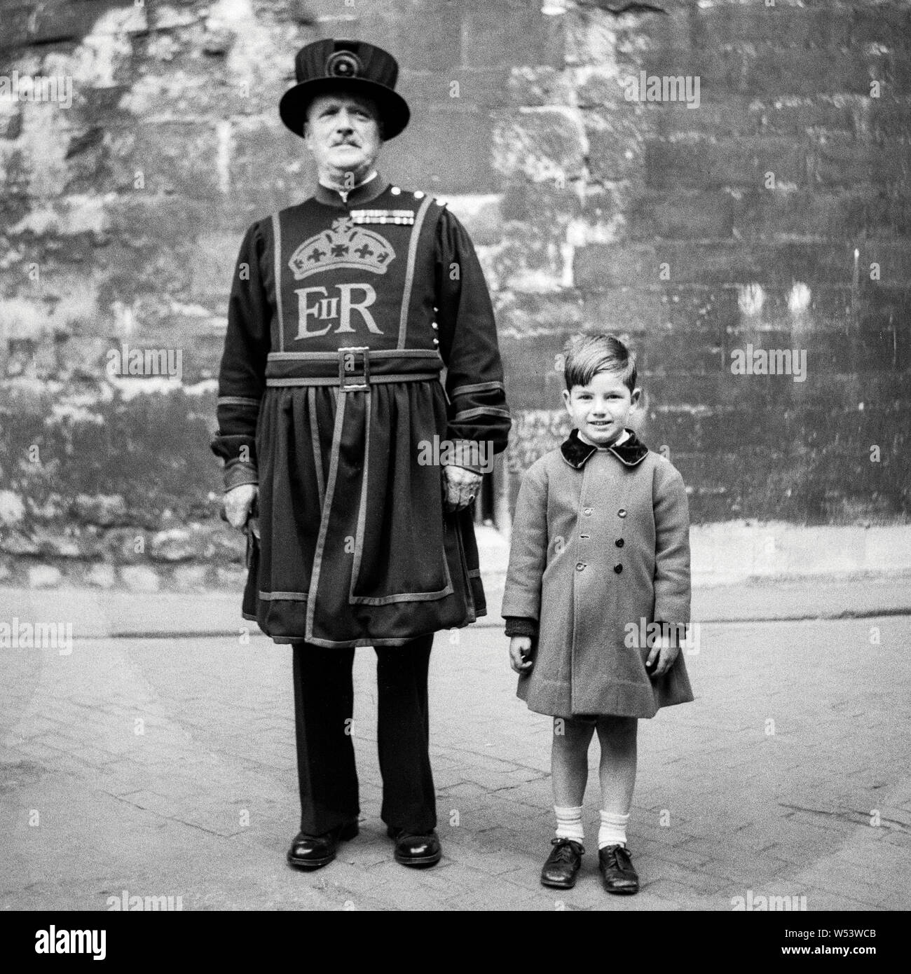 Ein Junge mit einem Beefeater am Tower von London 1955 posing Stockfoto