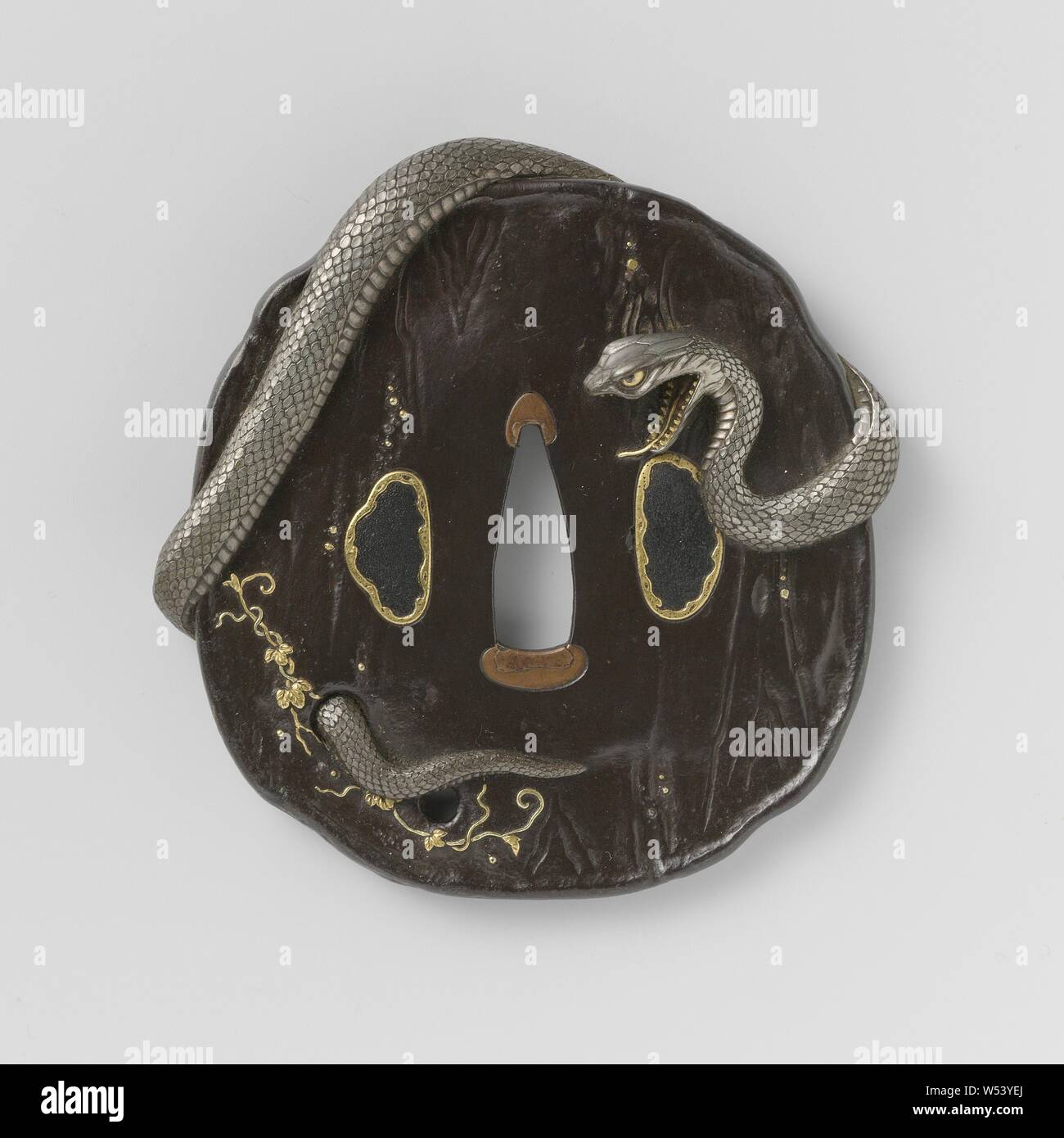 Handschutz, unregelmäßig geformte Tsuba mit Oberfläche in Holz Imitation, um die herum sich eine Silberne Schlange Spulen, Efeu Reben in Gold Inlays auf beiden Seiten unterzeichnet "unemasa"., Munemasa Shinoda (möglicherweise), Japan, 1800-1900, Edo-Periode (1600-1868)/Meiji-Periode (1868-1912), Eisen (Metall), Gold (Metall), Silber (Metall), h 9,0 cm x B 8,7 cm x T 1,5 cm Stockfoto