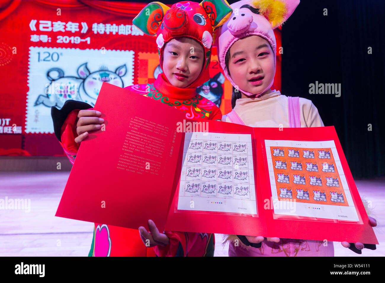 Kinder stellen besondere Sternzeichen Briefmarken für das lunare Jahr des Schweins in China Post in Nanjing Stadt ausgestellt, im Osten der chinesischen Provinz Jiangsu, 5. Januar 2019. Stockfoto