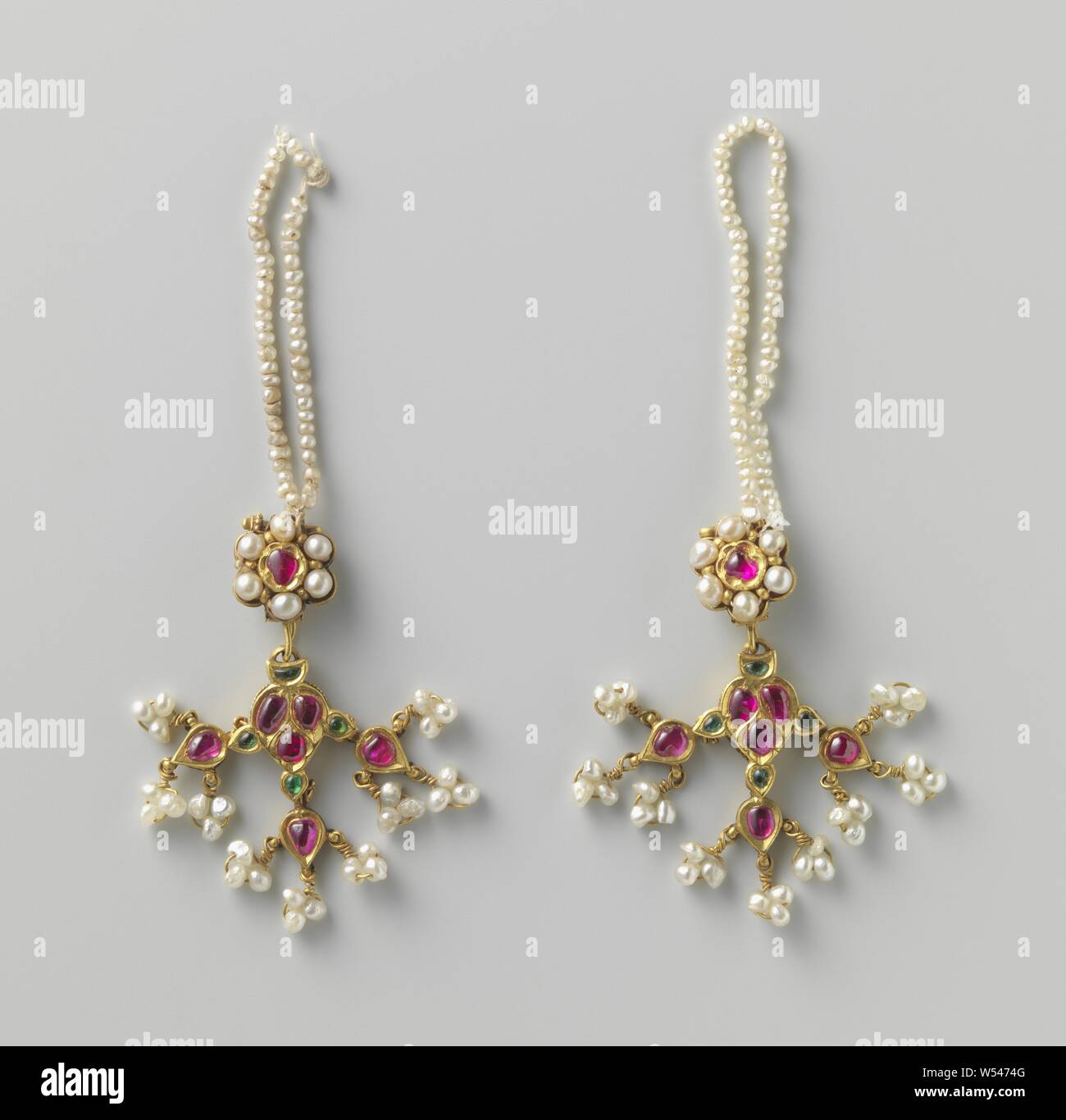Zwei Paar Ohrringe (pipalpati) Paar Ohrringe (pipalpati), ein Paar Ohrringe (pipalpati oder Dul) von Gold. In Form einer Perlenkette auf dem hängt eine goldene Rosette, Intarsien mit einem roten (?) Stein, durch eine Grenze von 6 Perlen umgeben. Auf der Rosette hängt eine blattförmige Ornament mit roten und grünen Steine mit Intarsien, auf denen 3 dito Kleineren, an dem drei Traversen von drei Perlen jedes Hang., anonym, Surat, C. 1750, gold (Metall), Pearl, h 10,0 cm Stockfoto