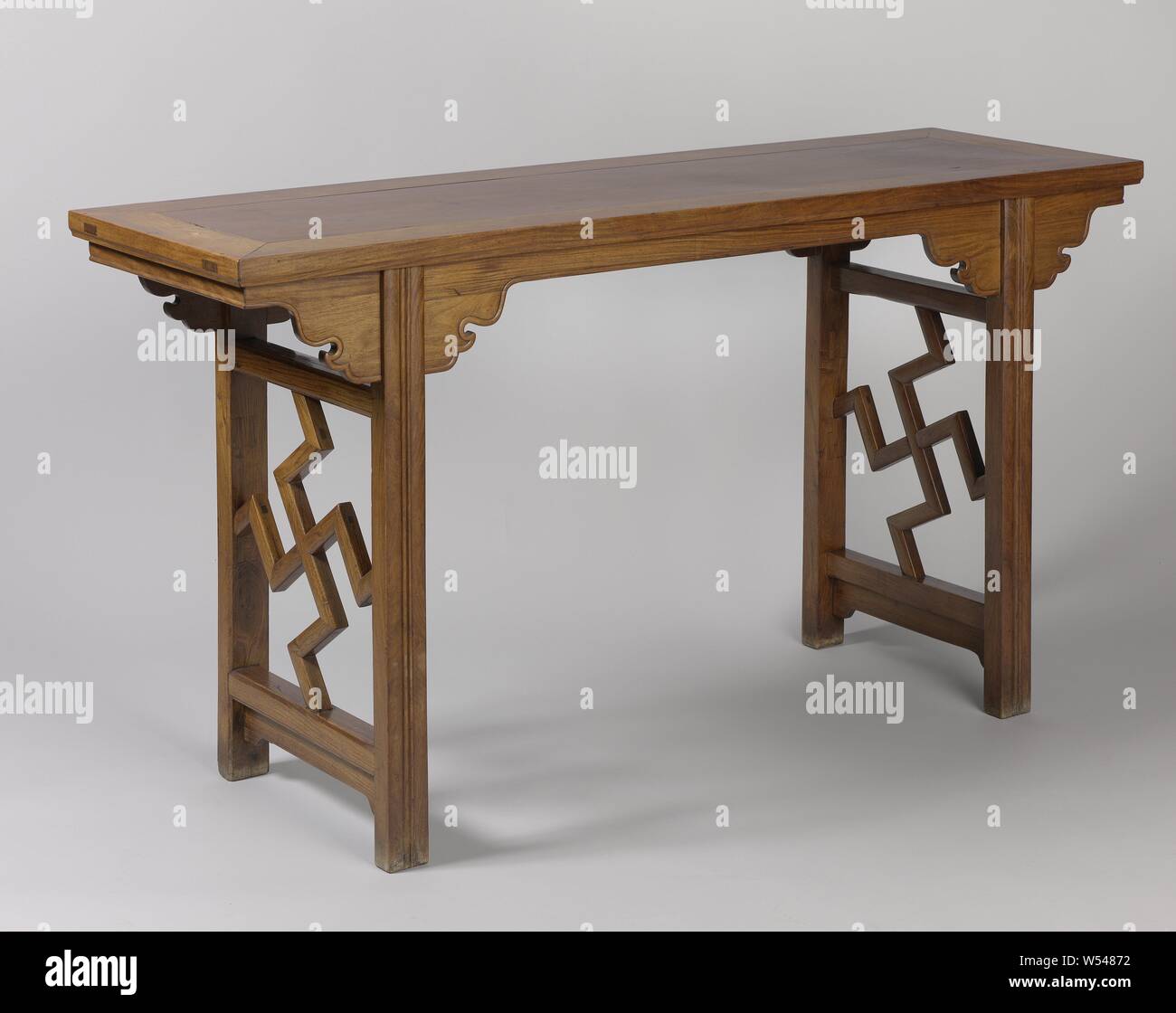 Tabelle, Huang - huali Holztisch, Ping-t'ou - eine der 'Ein'. Oben in der Tabelle durch ein einziges Teil in Messing und Groove in einem rechteckigen Langlöcher am Rahmen montierten gebildet wird, die die läuft nach unten zur Unterseite. Die Klinge liegt auf einer kreisförmigen Giebel und ist mit stilisierten Schlüsselinformationen auf beiden Seiten im Wok-Form (yuntoe), wenn sie an die Beine angeschlossen sind. Fronton und yuntou sind mit einem erhöhten Rand an der Außenseite. Die Tabelle steht auf vier Beinen abgeflacht, die mit cannelures an der Vorderseite ausgestattet sind. Die Verbindung zwischen den Beinen auf der Vorderseite wird durch zwei Linien gebildet Stockfoto