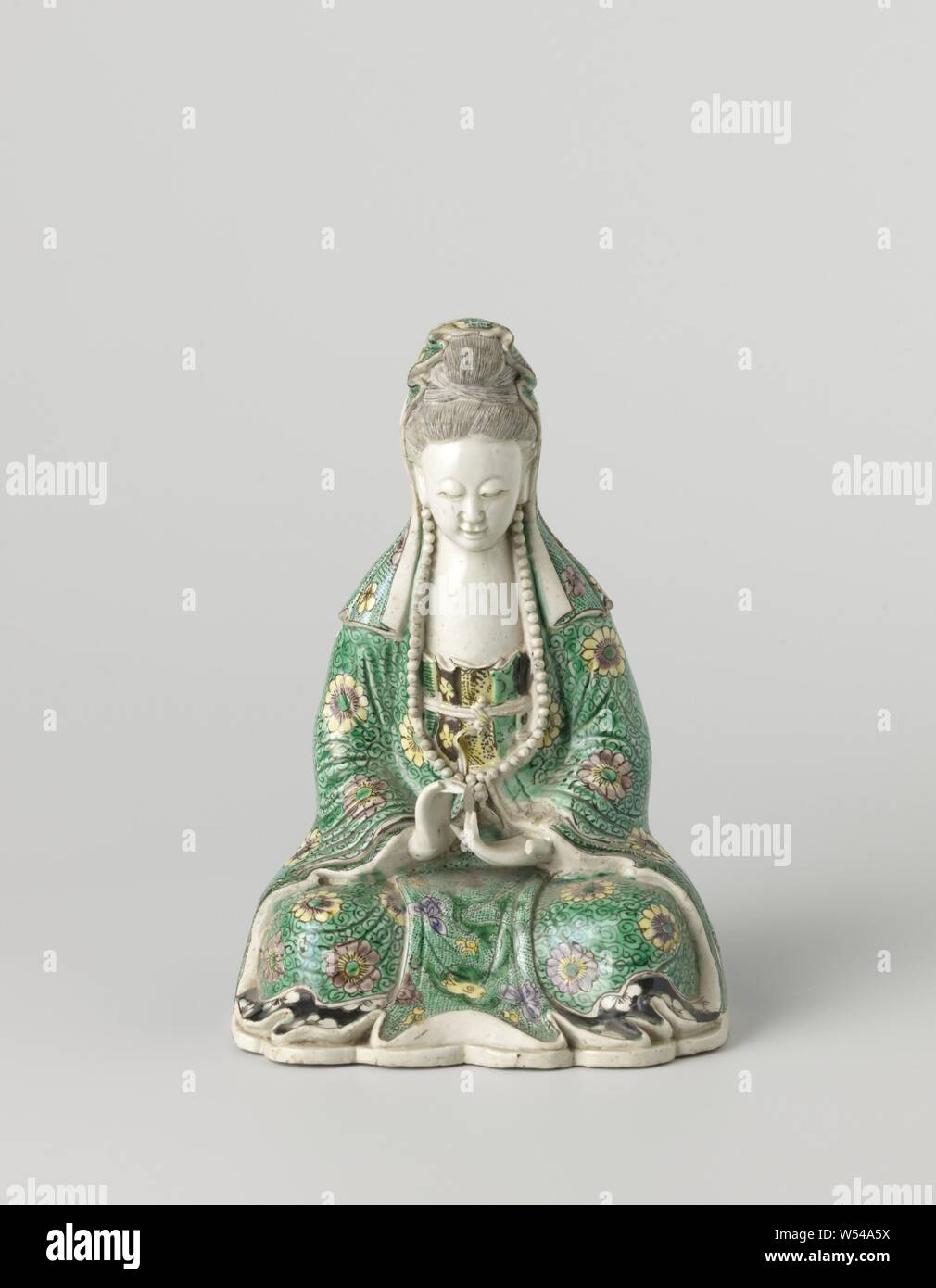 Abbildung einer sitzenden Guanyin, Skulptur von Porzellan auf einem Sockel, gemalt auf Kekse in Grün, Gelb, Aubergine und Schwarz. Sitzend Bild der Guanyin, ihre Robe ist mit Blumen und wirbelt mit einem Drachen auf der Vorderseite zwischen Lotus Blumen auf einem gesprenkelten, Grün Masse geschmückt. Rückseite mit einem Loch und zwei Kartuschen mit blühenden Pflanze oder Blume Weinstock, ansonsten schmucklos. Einige Finger sind abgebrochen. E-sur Keks mit Famille Verte Farben, Guan Yin, anonyme, China, C. 1800 - C. 1899, Qing- Dynastie (1644-1912), Porzellan (Material), Glasur, Verglasung, h 19 cm L 13,3 cm × w 9,2 cm Stockfoto