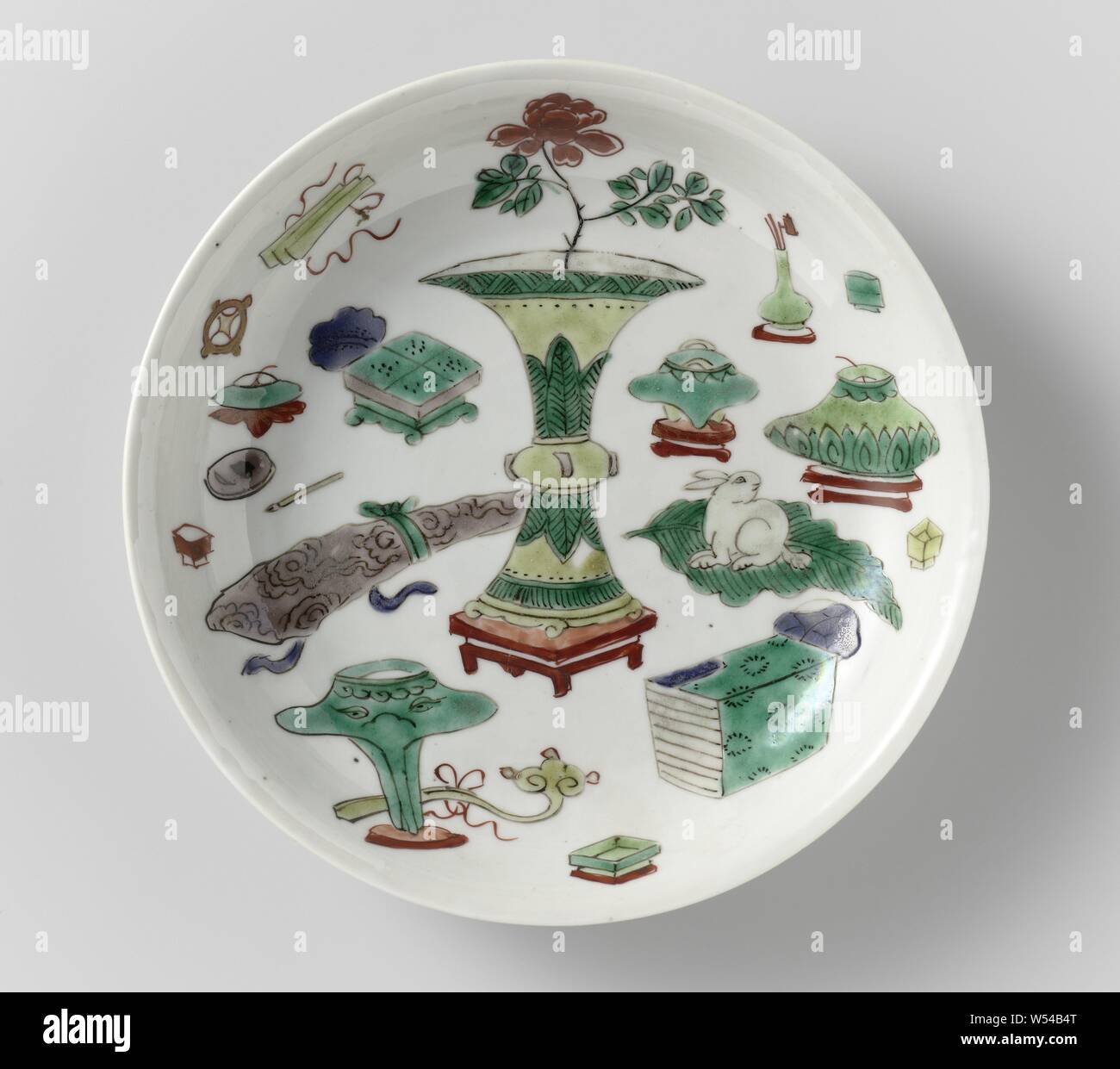 Untertasse - Teller mit wertvollen Objekten und Altertümern, Teller mit runden Wand aus Porzellan, in unterglasur Blau und auf der Glasur Blau, Rot, Grün, Gelb, Aubergine und Schwarz lackiert. Auf der flachen chinesische Antiquitäten, unten mit vier Wertsachen. Auf der Unterseite mit einer Dichtung in einem doppelten Kreis markiert. Famille Verte., anonym, China, C. 1700 - C. 1724, Qing- Dynastie (1644-1912)/Kangxi-Periode (1662-1722)/Yongzheng-Periode (1723-1735), Porzellan (Material), Glasur, Cobalt (Mineral), Verglasung, h 2,9 cm, d 16 cm, d 9,7 cm Stockfoto