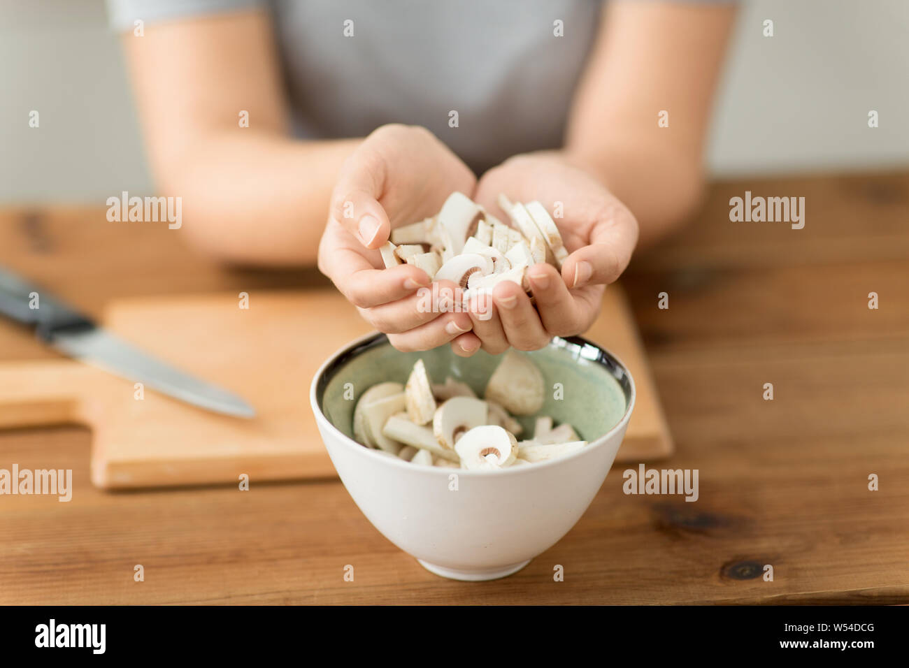 Nahaufnahme der Frau gehackt Holding Champignons Stockfoto