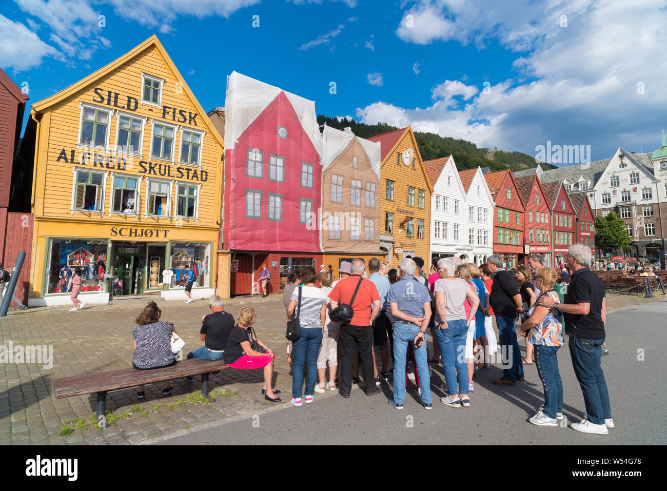 BERGEN, Norwegen - 28. JULI 2018: Touristen vor dem historischen Gebäude in Bryggen - Hanseatic Wharf. Bryggen wurde auf der UNESCO-Herita Stockfoto