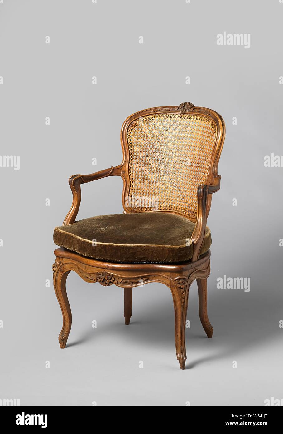 Sessel in Nussbaum mit S-förmigen abgewinkelten Beinen mit dem Schnitzen von Blüten und Blättern. Rückenlehne und Sitzfläche aus gewebtem Wicker. Mit losen Kissen, Sessel aus Nussbaum (Möbel) mit Rückenlehne und Sitzfläche aus gewebtem Wicker. Die erweiterte S-förmigen abgewinkelten Beinen mit Profilierung in den Sitz Rahmen ohne Unterbrechung zusammenführen und sind mit Blumen geschmückt. Überbackene Front mit Blume und Blatt. Armlehne struts positioniert nach hinten, S-förmige, hohlen Armlehnen endet in voluten. Obere Zeile Fenster mit eingefügten Voluten. Mit losen Kissen., anonym, Frankreich, 1750 - 1775, Holz (Pflanzenmaterial Stockfoto